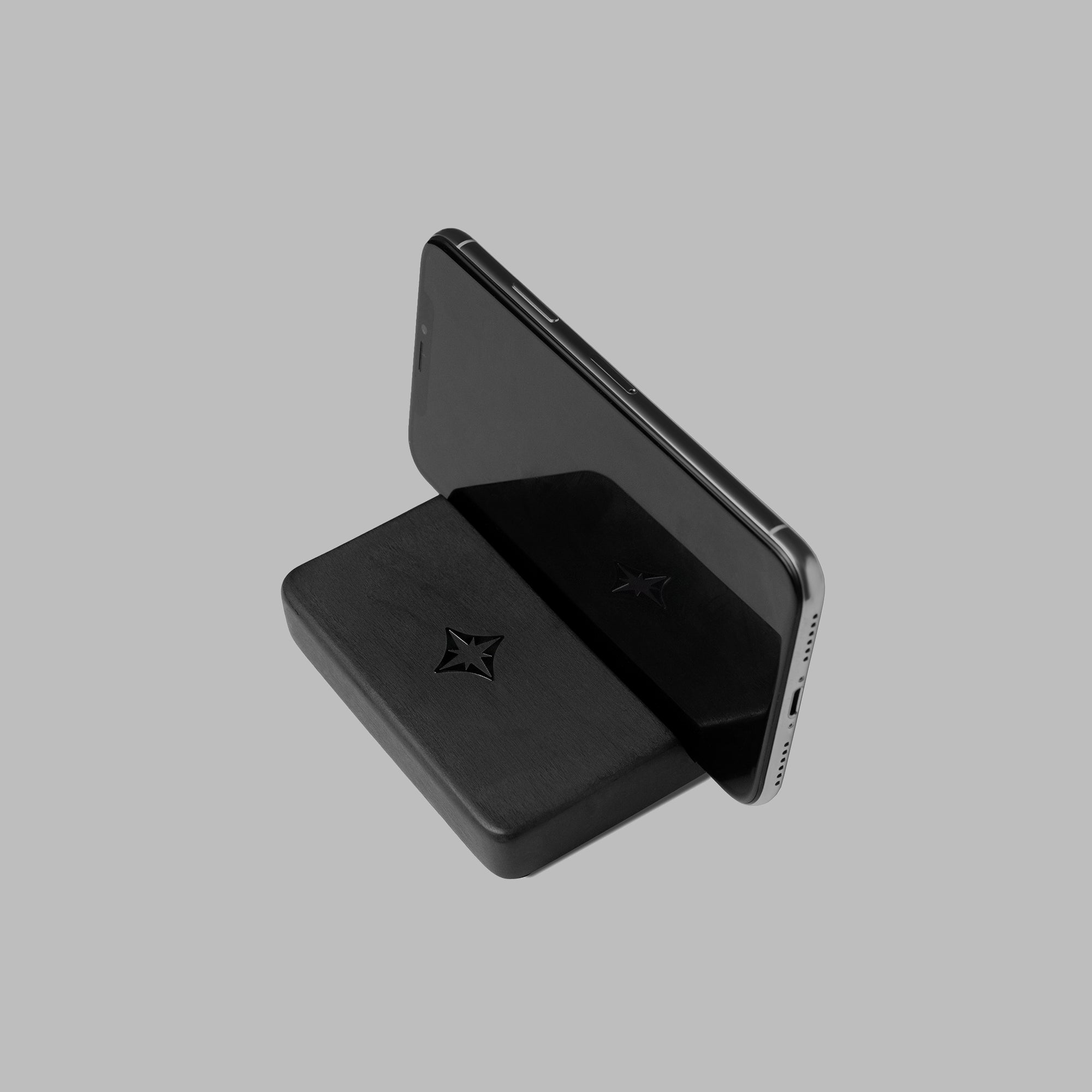 Black concrete phone holder on a dark surface, full view — BLACKVERSE
