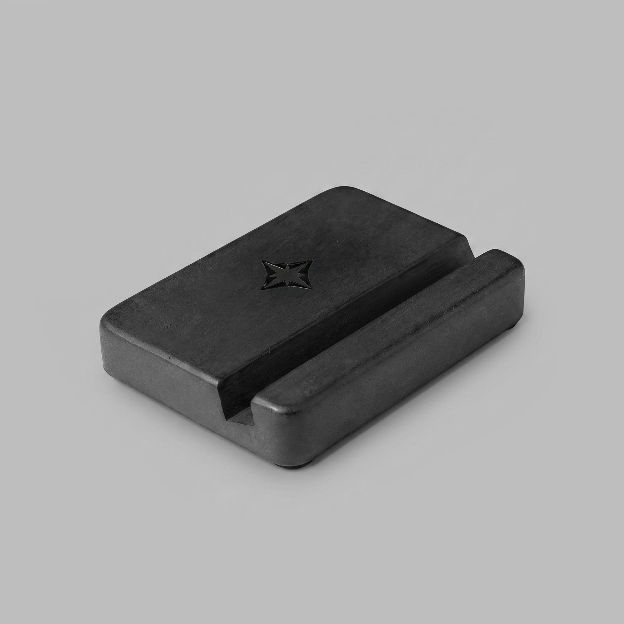 Black concrete phone stand, cast weight, side profile — BLACKVERSE