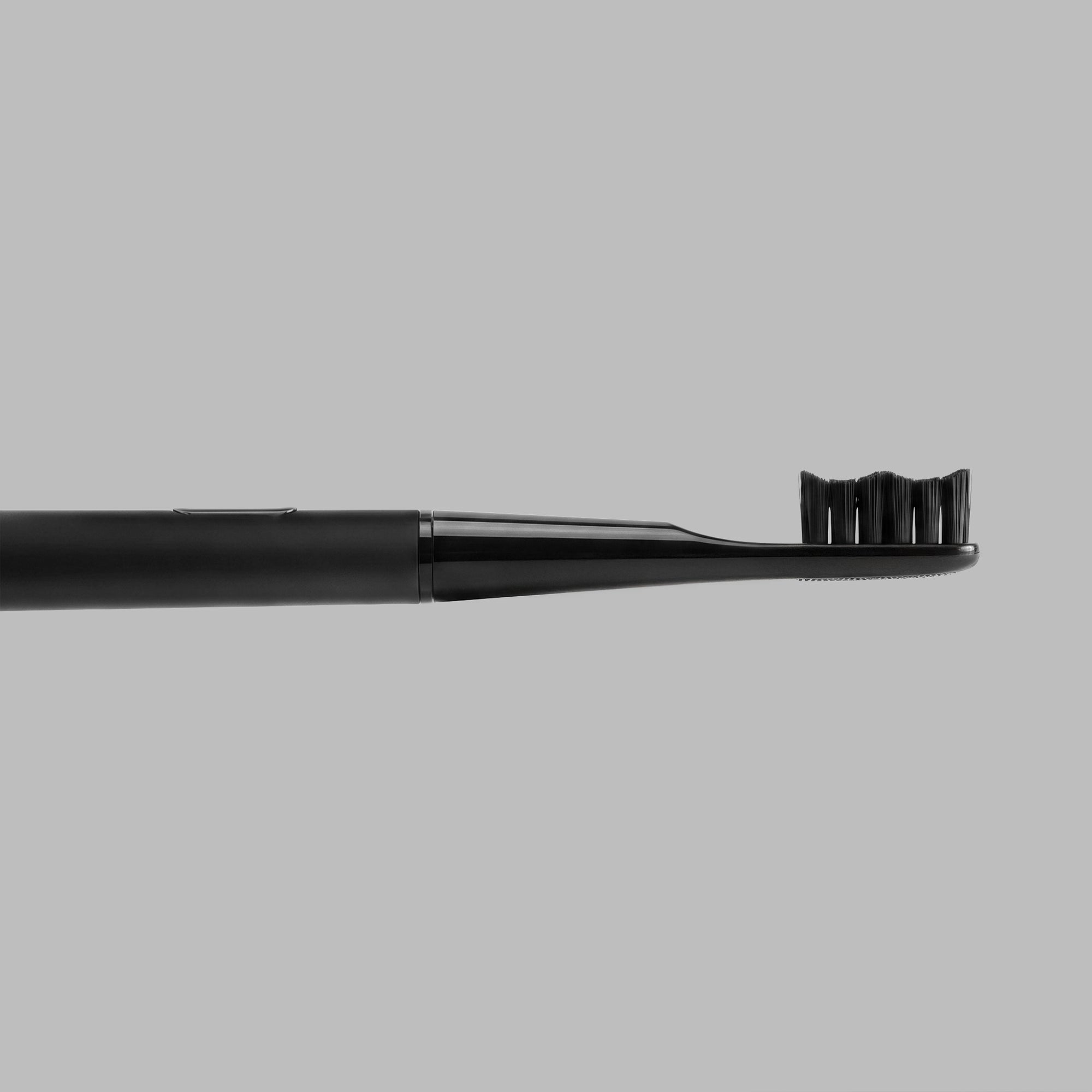 Black sonic toothbrush, side profile of the neck and brush head — BLACKVERSE