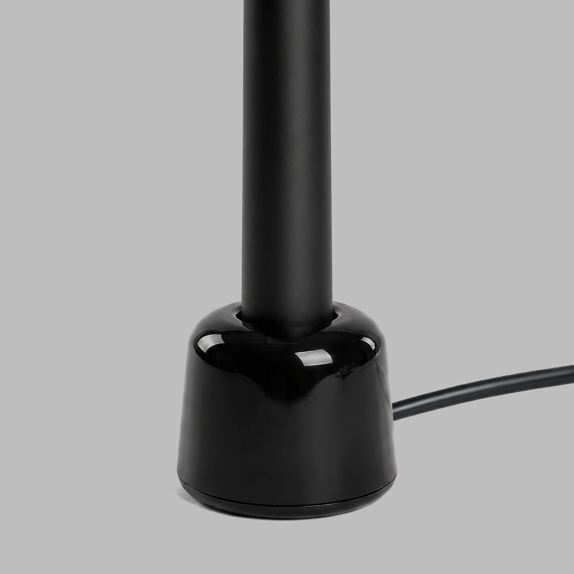 Black sonic toothbrush on its charging base, detail of the cable — BLACKVERSE