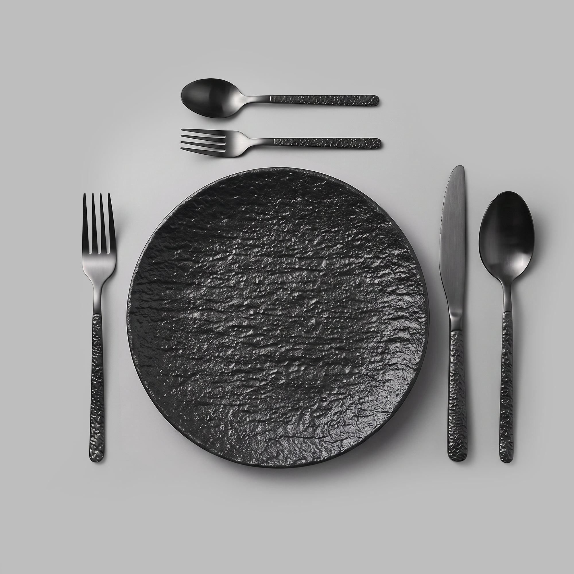 Matte-black cutlery laid as a single place setting — BLACKVERSE